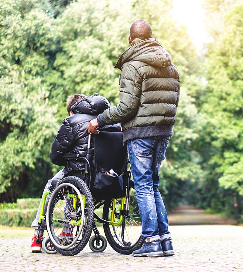 Support worker helping a wheelchair user outdoors