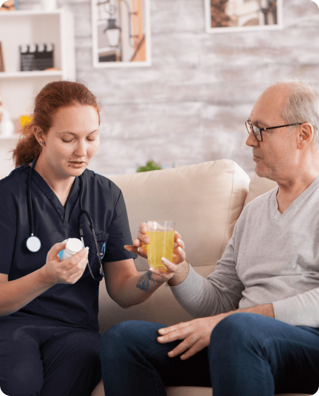 Carer supporting an elderly client with medication at home
