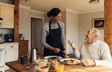 Professional caregiver assisting an elderly person with a nutritious meal